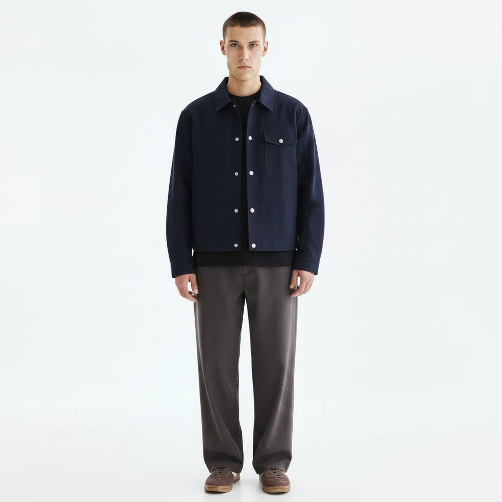 An indigo kendo haori jacket hanging open over a dark base layer