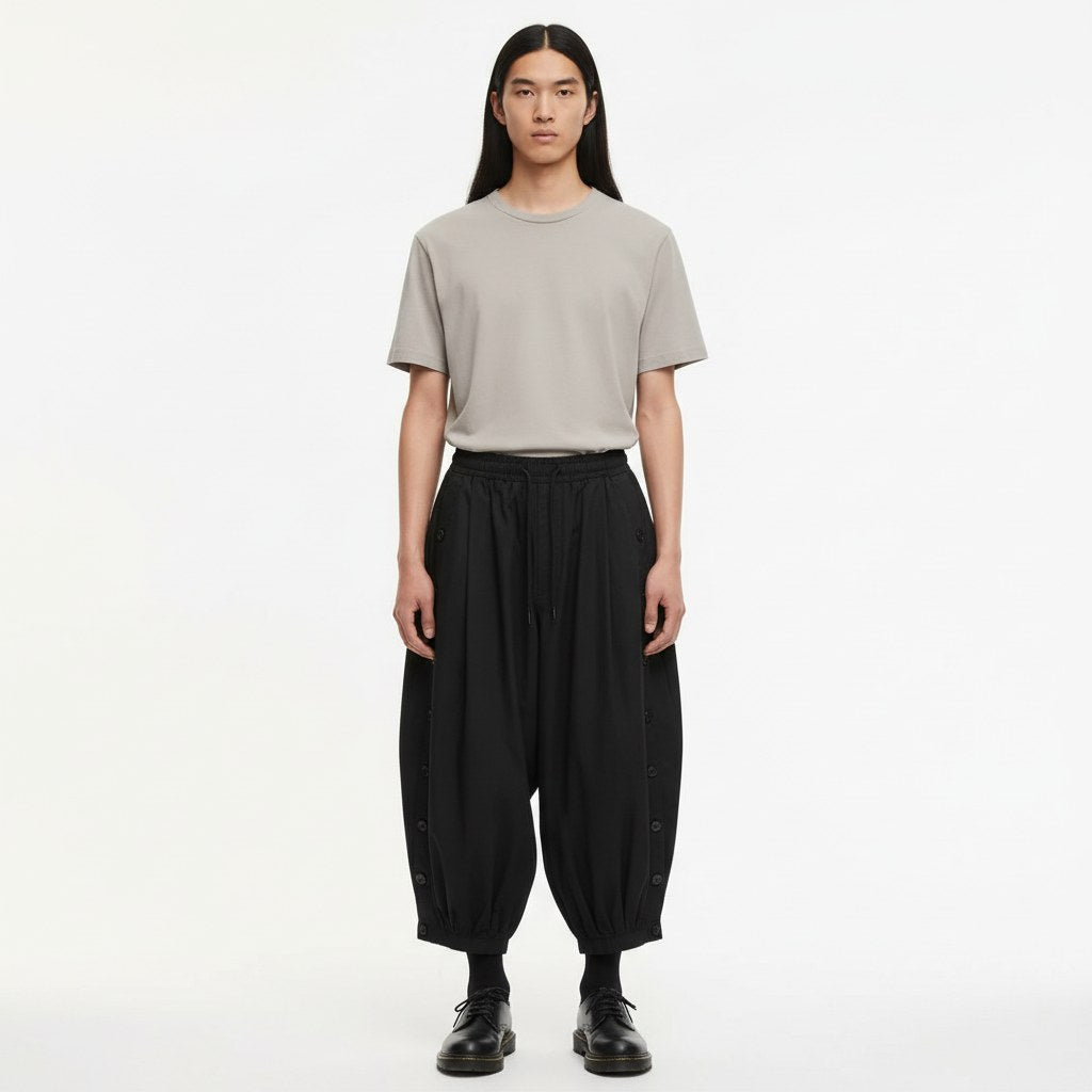 Black balloon-leg tobi trousers with gathered ankle cuffs, worn with a plain top