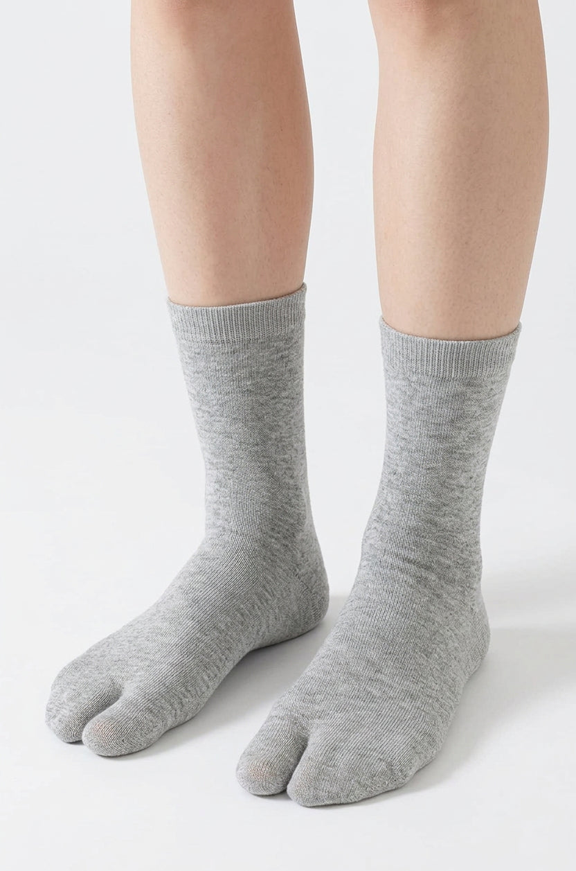 Grey split toe tabi socks worn to mid calf, showing the division between the big toe and the other four