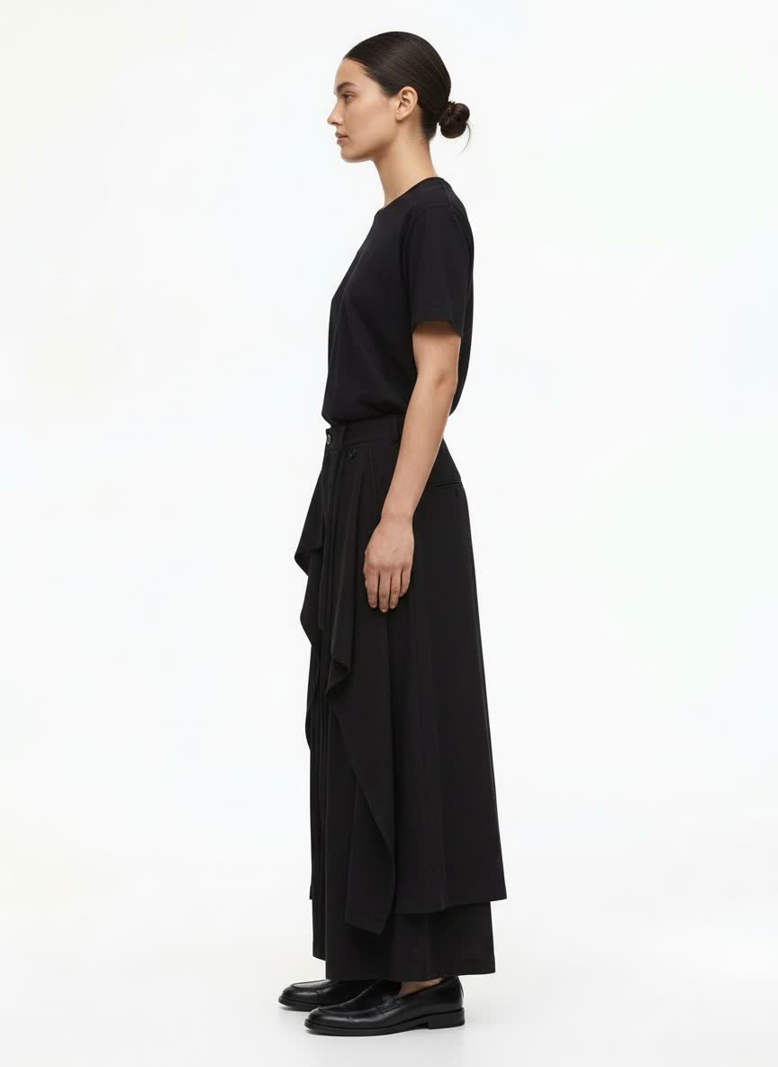 A woman wearing the black hakama pants, side view: the layered drape and long side ties