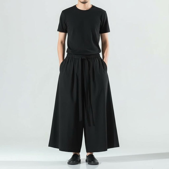 Men's lightweight hakama pants in black, front view: very wide leg and front tie belt