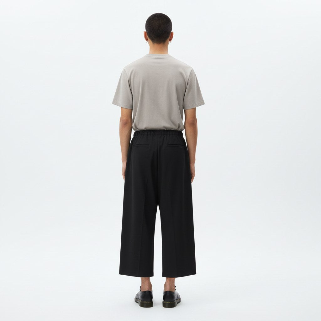 Strapped layered skirt pants on model in black, back view