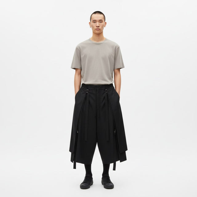 Strapped layered skirt pants on model in black, front view