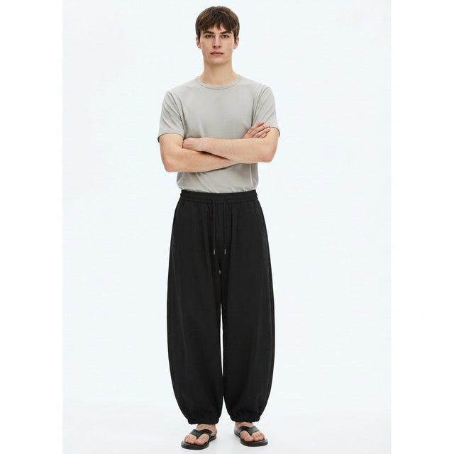 Wide lantern work pants in black, front view on model