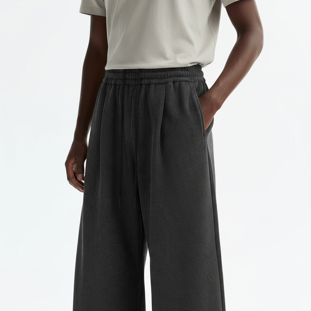 Pleated Wide Leg Sweatpants on model in charcoal black, detail view of the front pleats and drawstring