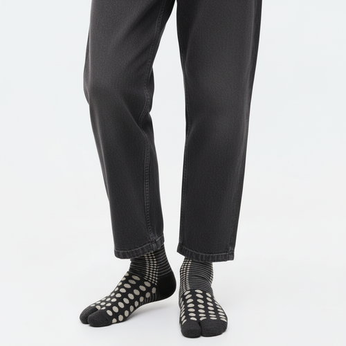 Japanese pattern tabi socks in Black Dots, split toe, mid-calf, close-up on feet