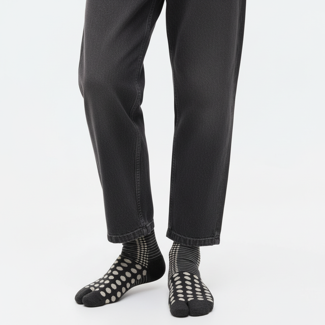 Japanese pattern tabi socks in Black Dots, split toe, mid-calf, close-up on feet